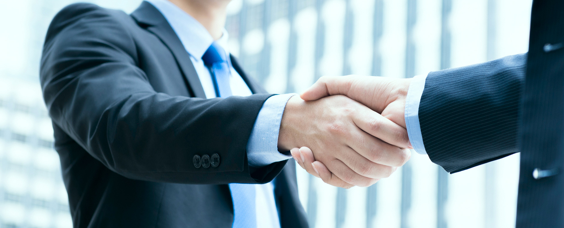 Two financial professionals in suits shaking hands